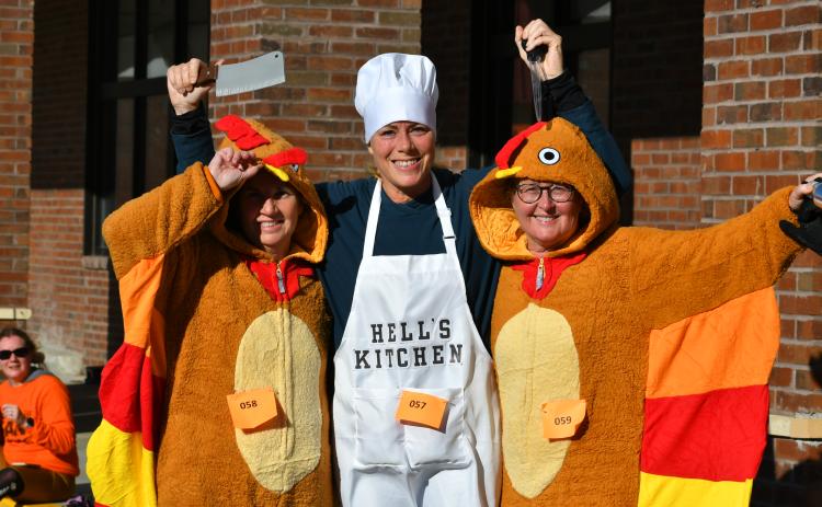 Wade Cheek/The Clayton Tribune. It looks like imminent demise for “turkeys” Regina Talley and Catherine Streible as Hell’s Kitchen chef  Nikki Zigler readies to do some carving. These costumed ladies were among the participants in the Turkey Trot event to raise money for the Food Bank of Northeast Georgia. The run was held on Thanksgiving morning. Read more about the fundraising effort on page B1 of this week’s edition.