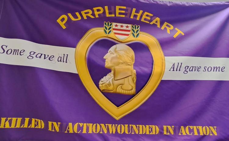 Megan Horn/The Clayton Tribune. The City of Sky Valley has been proclaimed ‘A Purple Heart City’ and displays this purple/gold flag at City Hall.
