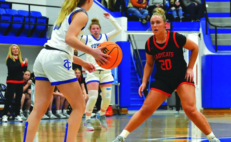 Wade Cheek/The Clayton Tribune. With head coach DeeDee Dillard watching on the left, senior Lady Cat Ellie Southards plays defense against Towns County in December.