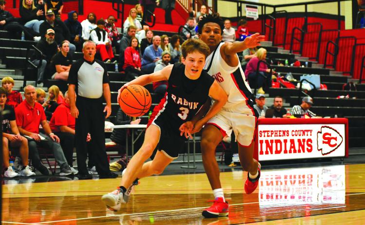 Wade Cheek/The Clayton Tribune. RCHS’s Huey Blalock drives to the hoop against Stephens County.