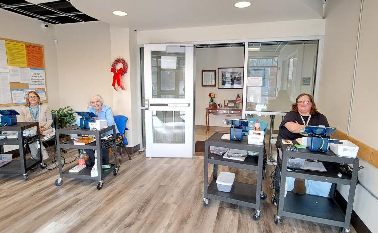Megan Horn/The Clayton Tribune. Rabun County Elections Office Poll Workers Hollie Greene, left, Ann D’Agostino and Amanda Burrell check in voters casting their ballots during Advanced Voting for the Presidential Preference Primary Tuesday. Early voting continues until Friday, March 8.
