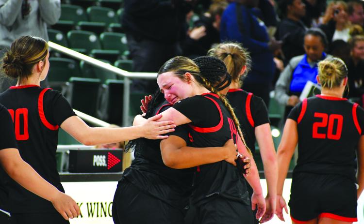 Wade Cheek/The Clayton Tribune. RCHS junior guard Jacie McCall hugs senior Isia Wilmont after the emotional loss to Galloway on March 1 that eliminated the Lady Cat basketball team from the state tournament.