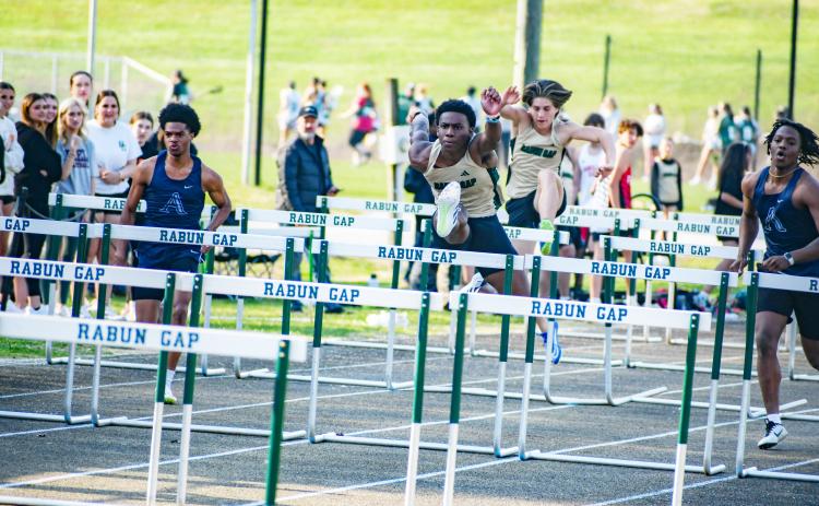 Wade Cheek/The Clayton Tribune. RGNS track and field hurdler Josh Buckhalter strides over a barrier to win the boys 110 meter hurdles during Rabun Gap’s home meet last Wednesday, March 20.