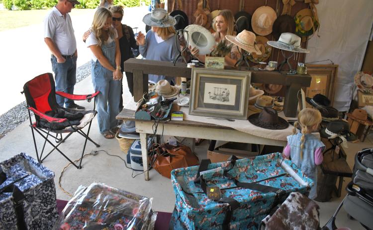 Enoch Autry/The Clayton Tribune. On a sunny day at the Of These Mountains event in Clayton, hat shopping is a must at the Rabun County Civic Center pavilions.