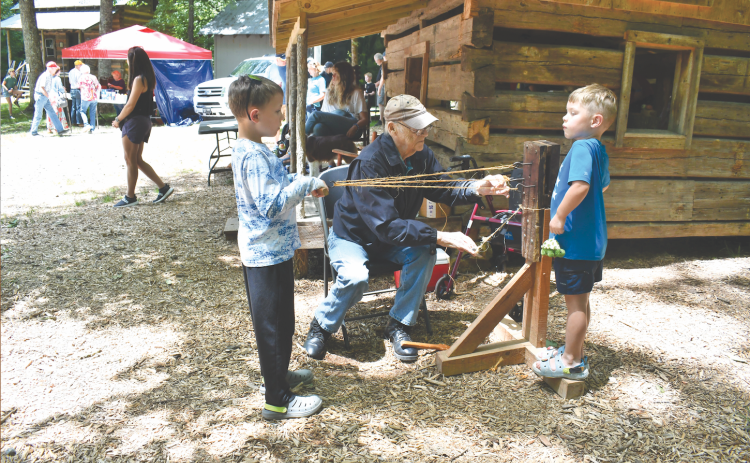 Megan Horn/The Clayton Tribune.  Kermit Rood demonstrates rope making at Foxfire Heritage Days last weekend to youngsters Archer Reinhardt, 8; and Brandt Reinhardt, 6. The event was held June 7 and 8  in Mountain City during the 50th anniversary of the beginning of the Foxfire Museum. Heritage Days continue to grow.
