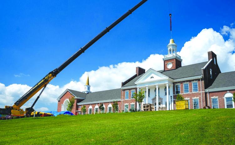 Submitted photo. Crews from Carroll Daniel Construction work to place the iconic Cupola back atop Hodgson Hall.