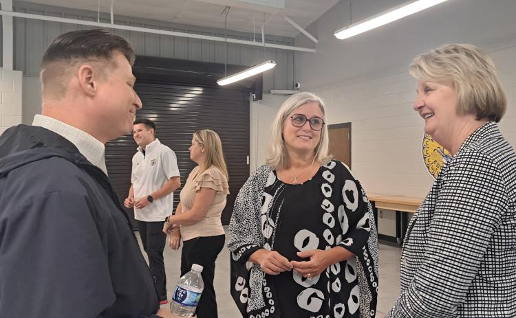 Megan Horn/The Clayton Tribune. Rabun County Schools Superintendent Dr. April Childers mingles with school officials, community leaders and board of education members during her retirement reception at the Rabun County Agricenter Tuesday. Pictured are Tony Penrose (left), Childers and Kathy McClure. Childers officially retires Sept. 30 and Steven Cole will become the full-time superintendent. Below: Rabun County Schools Superintendent Dr. April Childers converses with Mickey Duvall during her reception.