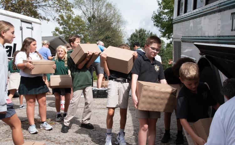 Submitted photo. Fifth graders load water onto TFS bus at Get Real Ministries before taking it to the Habersham Airport to be delivered to Western Carolina for those impacted by Hurricane Helene