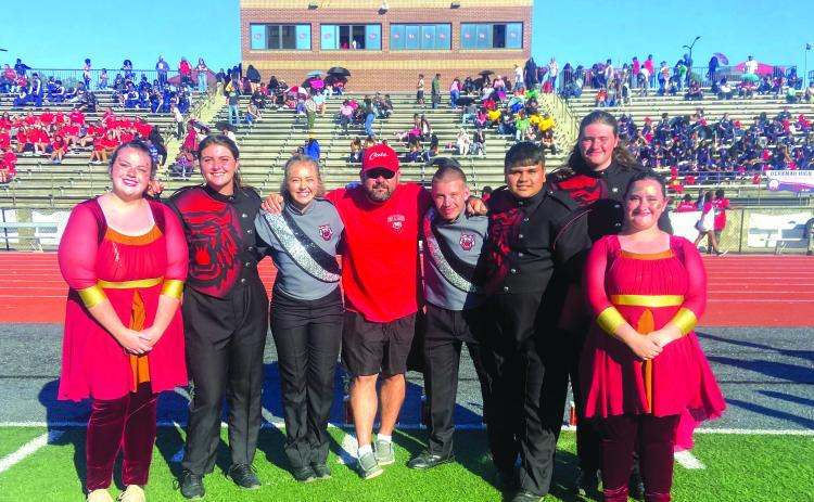 Following the Jaguar Classic, Lillian Seabolt, color guard captain; Lilly Padgett, drumline captain; Ashleigh Lewis, head drum major; Matthew Leff, RCHS director of bands; Jaden Horner, assistant drum major; Maxi Barrientos, band captain; Brady Mazarky, drumline captain; and Abby Streetman, color guard captain pose for a group photo.