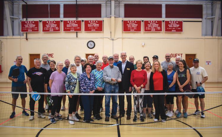 Wade Cheek/The Clayton Tribune. With Larry Walker holding the award, Rabun Pickleball Club members celebrate being named the GRPA’s statewide “Volunteer of the Year.”