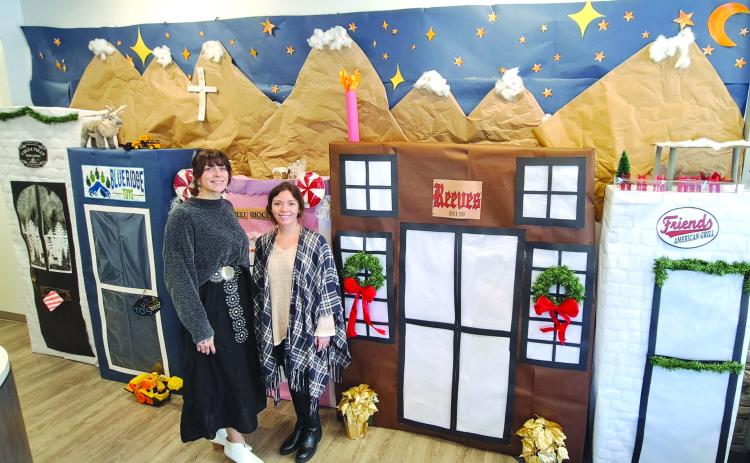 Megan Horn/The Clayton Tribune. Casidi Collins and Hayleigh Gosnell, tellers at My Georgia Credit Union in Clayton, are excited about their holiday decoration detailing popular Main Street businesses. The detailed display won them first place in the annual decorating contest held among the eight branch locations.