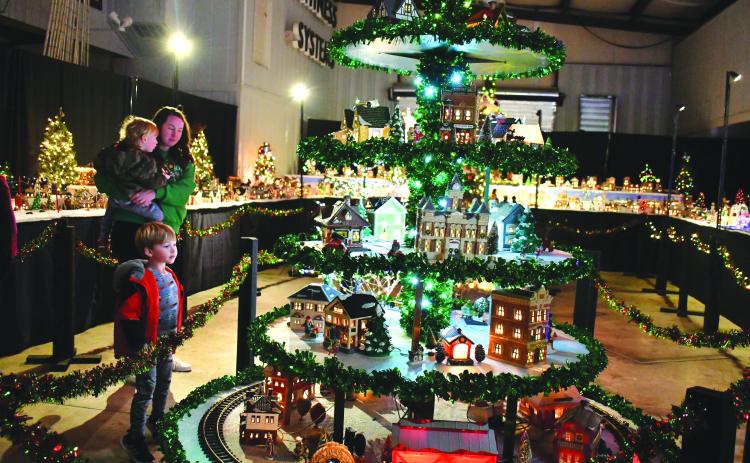 File photo/Megan Horn. The Stille family of Spencer, Jennifer and Sutton gaze at the miniature village that includes a train at last year's Village of Lights benefitting Fight Abuse In The Home (F.A.I.T.H.).