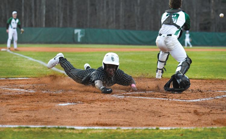 Wade Cheek/The Clayton Tribune. Senior infielder and Bryan College signee Denajh Williams dives in safely to score a run in Rabun Gap’s 19-0 win over Tallulah Falls School on Monday, Feb. 17.