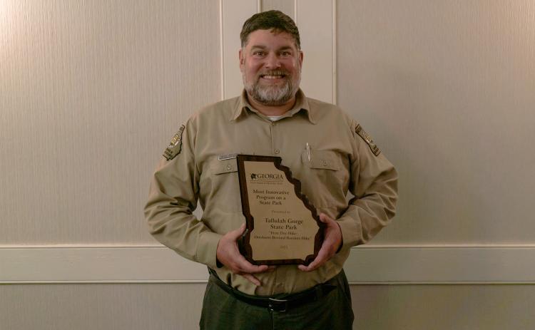 Submitted photo. Tallulah Gorge State Park won the Most Innovative Program on a State Park award. Pictured is West Malenke, Interpretive Ranger for Tallulah Gorge State Park, with the award.