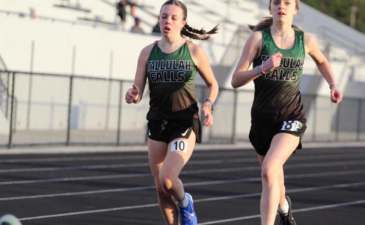 TFS Athletics. Tallulah Falls girls track and field team members Olivia Henderson and Mary Kate Ball complete a lap around the East Jackson track.
