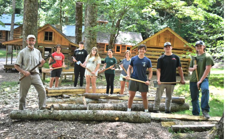 File/Megan Horn/The Clayton Tribune. Local students participated in the 2023 Foxfire Summer Leadership Program, now called “Project Foxfire,” where they helped Foxfire Museum Director Barry Stiles hew logs to build the miniature replica Blacksmith Shop, which is now featured in the Children’s Village. Students pictured from the 2023 program include Luke Thompson, Sam Flaherty, Celton Littrell, Sean Flaherty, Brinn Justice, Gavin Sharpe, Lily Karplus and Olivia Nixon.