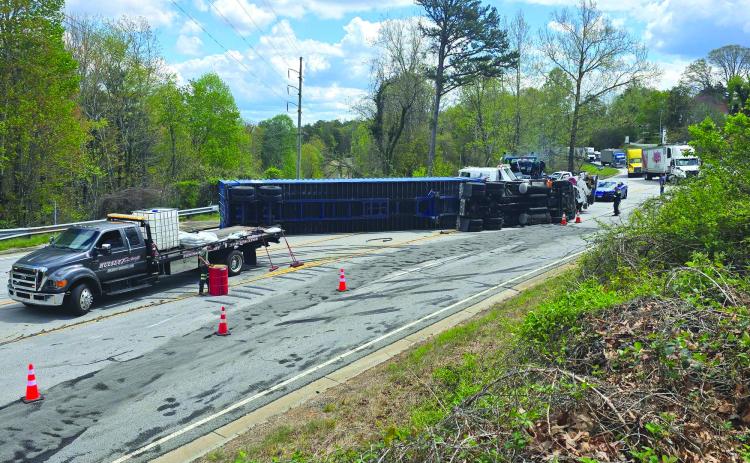 Enoch Autry/The Clayton Tribune. : A tractor trailer rests on its side on Highway 441 in Tallulah Falls on April 11 as crews attempt to clear the scene and get the vehicle upright.