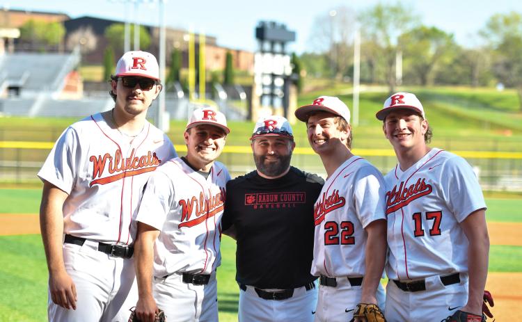 Wade Cheek/The Clayton Tribune. Rabun baseball’s 2025 seniors stand with head coach Wesley Satterfield (center) ahead of their region win over Athens Academy on Tuesday, April 8. This year’s senior class includes (from left) Michael Johnson, Parker Smith, Carver Jarrard and Elvis Hunt.