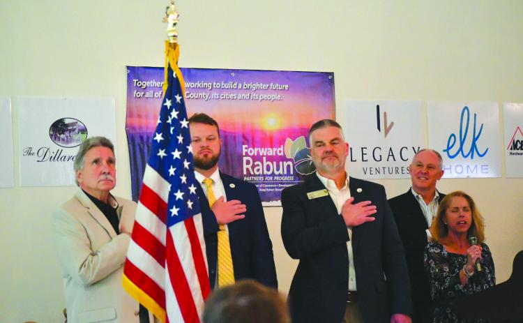 Enoch Autry/The Clayton Tribune. The Dillard House Conference Center served as the site for the Forward Rabun/Rabun County Chamber of Commerce Spring Business Breakfast as elected officials answered questions from the public. With Suzie Nixon Flaherty (far right) singing the “National Anthem,” Rabun County Commission Chair Greg James, State Sen. Bo Hatchett, State Rep. Victor Anderson and chamber president Rick Story stand at attention for the American Flag to begin the April 17 event.