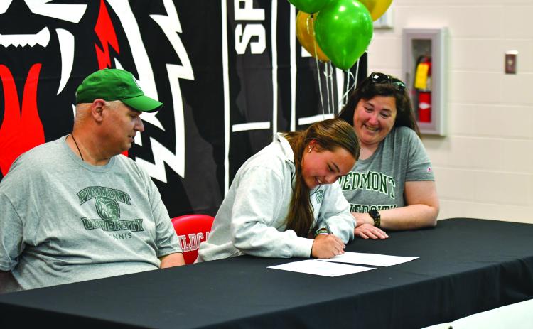 Wade Cheek/The Clayton Tribune. RCHS senior tennis player Lucy Harvey signed her national letter of intent to play tennis for Piedmont University on Friday, March 28. Harvey is currently the top singles player for the Lady Cats.