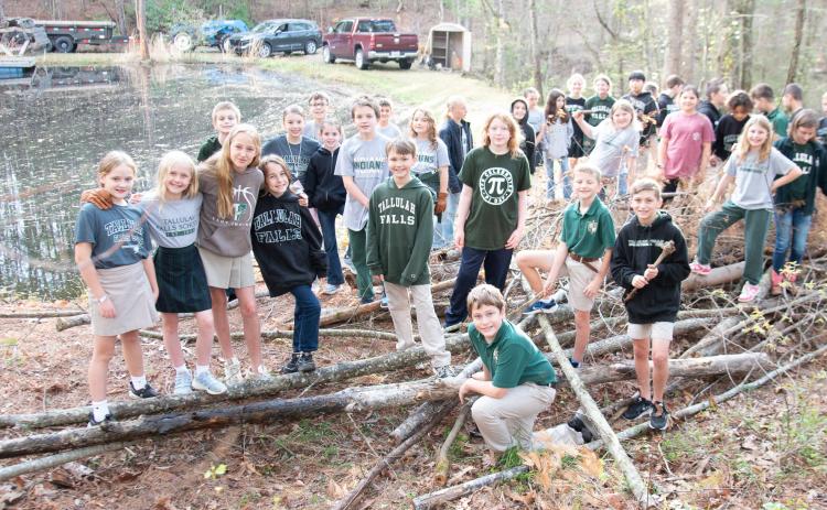 Photo courtesy of Tallulah Falls School. Tallulah Falls School fourth and fifth graders show off the pile of debris they collected during the clean up project.