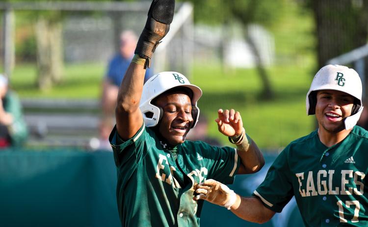 Wade Cheek/The Clayton Tribune. Rabun Gap senior infielders Denajh Williams (left) and Brenden Rosado (right) celebrate runs in their win over Tallulah Falls School. The Eagles have stayed hot since, scoring 12 runs in their most recent win over Christ School.