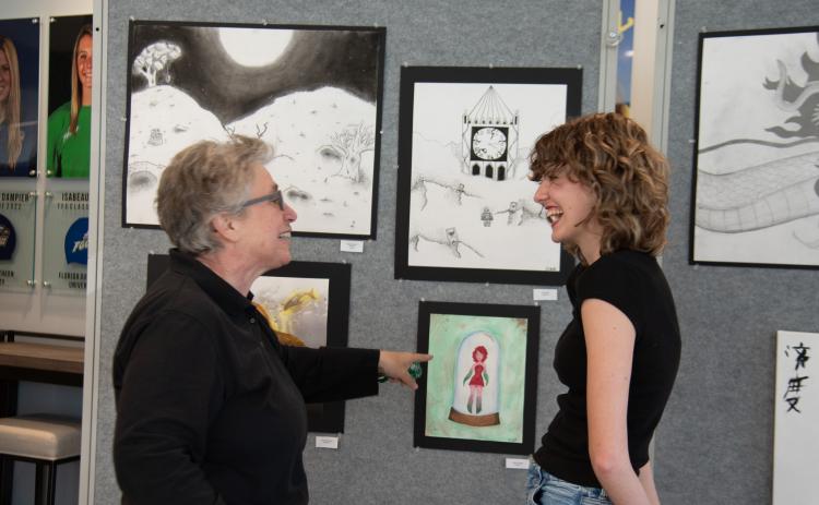 Submitted photo. :TFS sophomore Olivia Bonner shows middle school counselor Elizabeth Kyle a piece of her artwork at the Evening of the Arts.