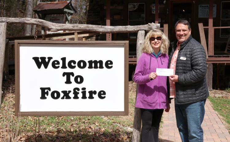 Megan Horn/The Clayton Tribune. Karen Bacon, Rotary Club of Clayton Foundation chair (left), presents Foxfire Executive Director Todd Faircloth with proceeds in March to help fund the removal of trees on the Foxfire property.