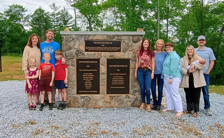 Megan Horn/The Clayton Tribune. Community members attended a dedication ceremony of the 750,000-gallon, ground-level water storage tank located on Yorkhouse Road in Rabun Gap. Pictured are Peters’ family members including Sarah Peters, Joel Peters, Joanna Radford, Susan Peters, Jennifer Peters, Jaimie Crane holding Susie in her arms, John Crane, Eloise Peters, Xander Peters and Tatham Peters.