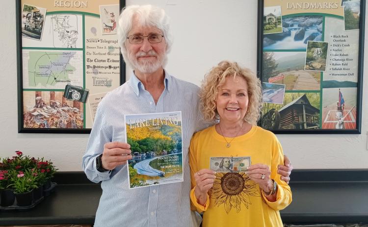 Megan Horn/The Clayton Tribune. Spring 2025 “Lake Living” cover winner Morgan Harvill (left) is pictured with his wife, Judy. The magazine cover features a MasterCraft boat on Lake Rabun in Rabun County at the narrows around September 2024. In addition to gracing the cover of Spring 2025 “Lake Living,” Harvill received $100.