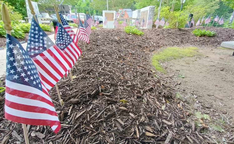Megan Horn/The Clayton Tribune. Community members placed 48 flags at the memorial for “all who served honorably” and passed away this past year during the Monday, May 26, Memorial Day Ceremony.