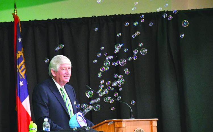 Enoch Autry/The Clayton Tribune. Graduation speaker Dink NeSmith, co-owner of Community Newspapers, Inc., utilizes a soap bubble machine during his speech, noting how bubbles are like dreams. NeSmith told the Tallulah Falls School graduates to remember a “no” can be a stumbling block or it can be a stepping-stone in their path to making their dreams come true.