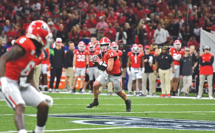 Wade Cheek/The Clayton Tribune. Georgia quarterback Gunner Stockton scrambles to complete a pass to wide receiver Dominic Lovett in January’s Sugar Bowl loss to Notre Dame. Stockton, tops on the UGA depth chart heading into the 2025 football season, was a state record-setting quarterback for Rabun County.