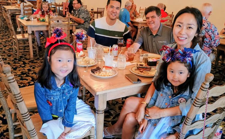 Megan Horn/The Clayton Tribune.  It was family fun at The Dillard House on July 4 for annual Independence Day celebrations. The Dillard House has been celebrating the tradition for decades. Pictured enjoying their buffet meal are Emmy Lim, 6; David Lim; John Dillard, Legacy Ventures and Manager of The Dillard House; Stella Lim; and Colette Lim, 4, dressed in patriotic attire as they enjoy the festivities.