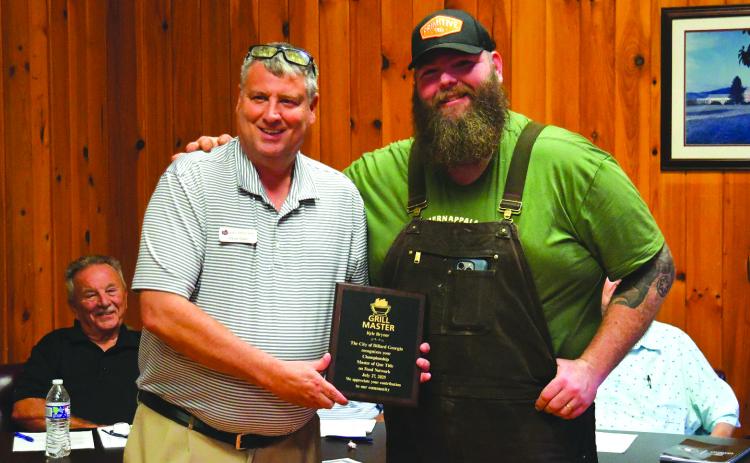 Enoch Autry/The Clayton Tribune. Dillard Mayor Claude Dillard presents Kyle Bryner with a plaque from the City of Dillard for the owner of Blue Hound’s reality cooking show win on the Food Network’s “BBQ Brawl” for season six.