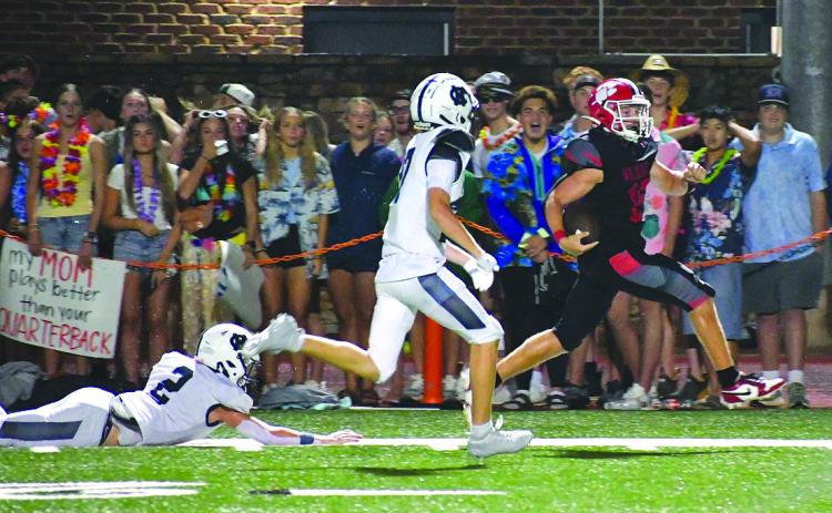 Enoch Autry/The Clayton Tribune. Rabun County senior running back Reid Giles sprints down the sideline in front of a group of RCHS students on Aug. 15 for a 65-yard touchdown against visiting White County in the Wildcats’ 42-6 win on “Hall of Fame Night.” Giles, a preseason all-state selection, scored three TDs.