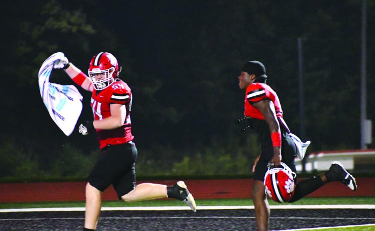 Enoch Autry/The Clayton Tribune. Ryan Yearwood and JK Fruster celebrate the Wildcats’ win over Fannin County on Aug. 22 as they run to ring the bell.