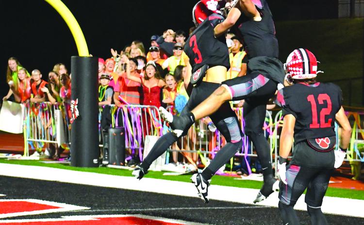 Enoch Autry/The Clayton Tribune. Rabun County senior quarterback Ty Truelove celebrates with freshman Cooper Kowalsky (3) after the signal caller runs 69 yards for a touchdown. The score by Truelove was his fifth TD of the night against Banks County in the Homecoming win. In the background, the RCHS student section cheers on their Wildcats. In the front is Hayden Bass, who was crowned as the 2025 Homecoming Queen at halftime.