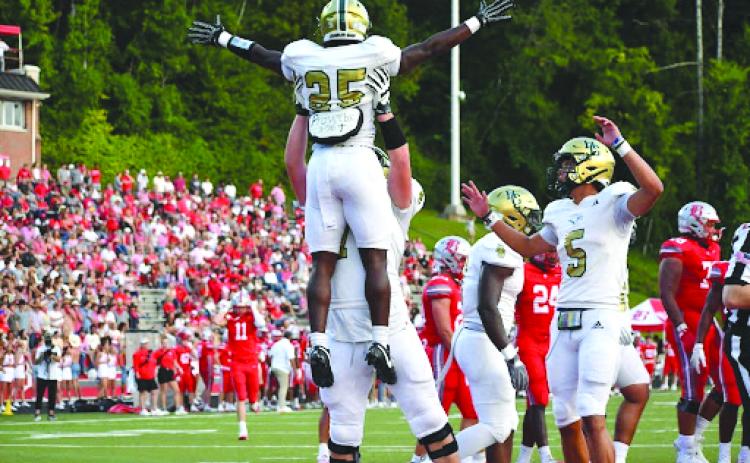 Wesley Branch/The Clayton Tribune. Rabun Gap offensive lineman Wilson Zierer lifts running back Jordan Lindo into the air in celebration after a 5-yard touchdown against Baylor on Aug. 29. The Eagles earned their first win of the season the next week at Massillon Washington High School, 50-35.
