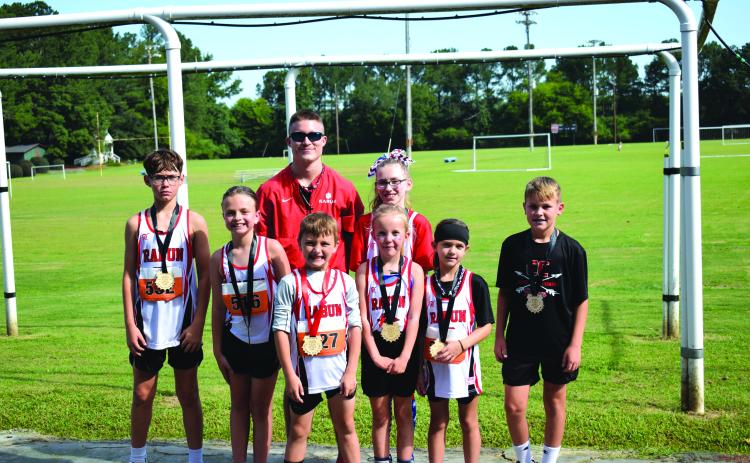 Submitted Photo. Top 10 finishers pictured along with Head Coach Ed Eidson, include Caiden Wood, Harper Westbrook, Owen Moseley, Madison Anderson, Opal Aker, Nora Webb, and Keegan Hanifan-Wagner.