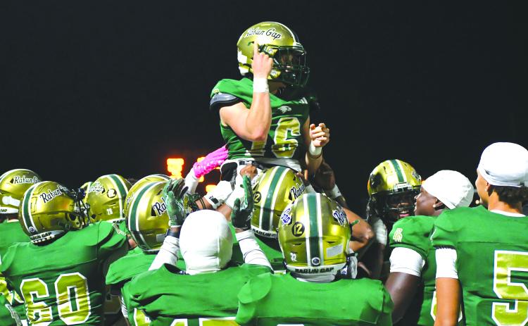 Wesley Branch/The Clayton Tribune. Rabun Gap players lift up quarterback Hector Nahle in celebration after Nahle scores a rushing touchdown versus Christ School in the Eagles’ 42-0 win over the Greenies on Oct. 17.