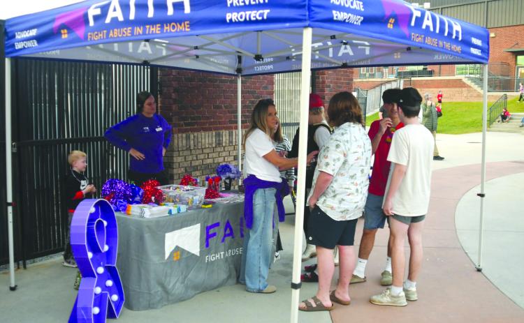 Enoch Autry/The Clayton Tribune. Members of F.A.I.T.H. had a tent at the Oct. 3 football game between Rabun County and Commerce to provide people with information about awareness for domestic violence and dating violence.
