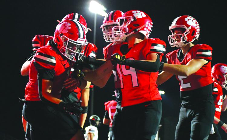 Enoch Autry/The Clayton Tribune. Senior Lake Evans (left) is congratulated by his Rabun County teammates after the running back rumbles 36 yards for a rushing touchdown in the Wildcats’ 55-28 home win over region foe Commerce.