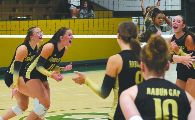 Wesley Branch/The Clayton Tribune. Rabun Gap volleyball players celebrate after the game-winning point versus Tallulah Falls School on Aug. 19. The Eagles’ 14 regular season wins are already more than the team had last season.