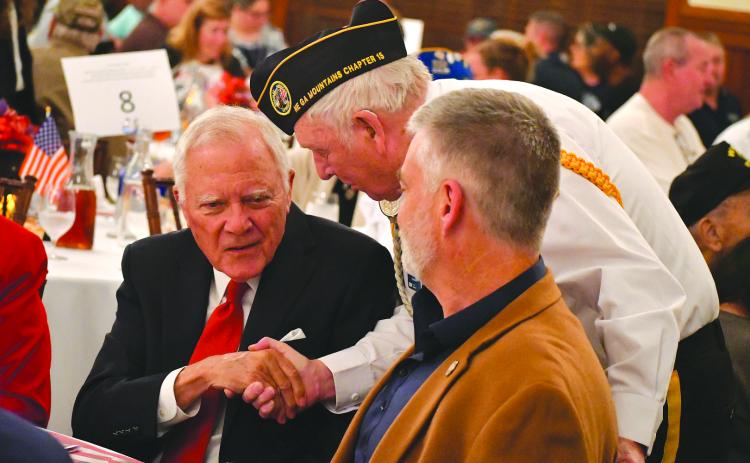 Enoch Autry/The Clayton Tribune. Doug Wayne of the Northeast Georgia Mountains Chapter 15 of Disabled American Veterans shakes the hand of former Georgia Gov. Nathan Deal at the 26th annual Veterans Appreciation Dinner at The Dillard House Resort. In the foreground is State Rep. Victor Anderson.