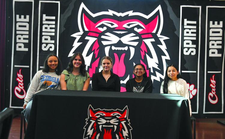 Enoch Autry/The Clayton Tribune. abun County Middle School eighth graders and new REACH scholars Kinley Burtch, Paytn Sharkey, Jasmine Nelson, Neyli Aguilar and Ana Espitia Martinez pose for a photograph at the conclusion of their Nov. 10 signing ceremony.