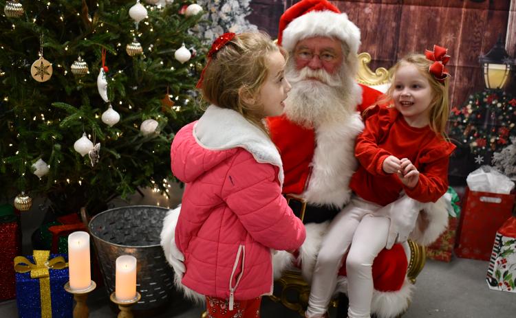 Megan Horn/The Clayton Tribune. Lyla Messer, 6; and Gentry Messer, 4, happily visit Santa “On the Farm” and tell him what they want for Christmas, during the Dec. 4 event hosted by the RCHS and RCMS FFA chapters.