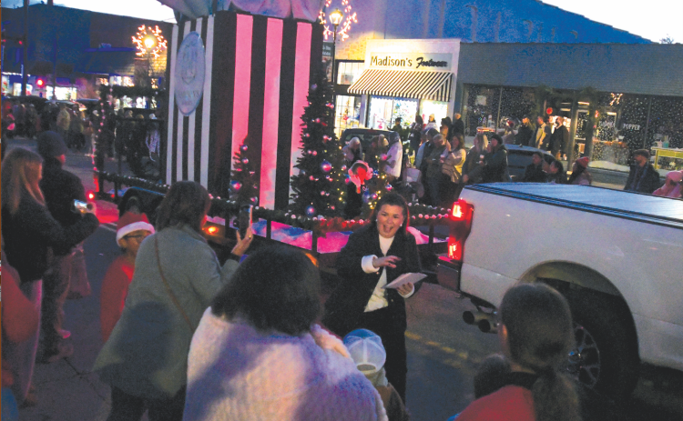 Enoch Autry/The Clayton Tribune. Madison’s on Main won “Best Overall Float” for its giant shopping bag that was among the entries that rolled down Clayton’s Main Street for the annual Christmas Parade. In the background is the business that is located at 41 Main Street. Thousands attended the Dec. 6 event with lighted floats.