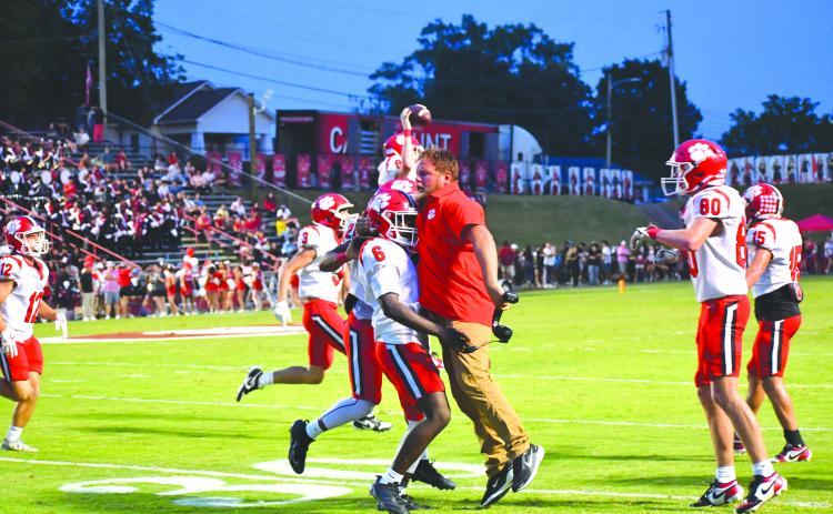 Wesley Branch/The Clayton Tribune.  Rabun County junior linebacker JK Fruster celebrates with assistant coach Ty Maxwell after the Rabun County defense forces a turnover in the Wildcats’ 49-42 road win over Dalton on Sept. 5, 2025.