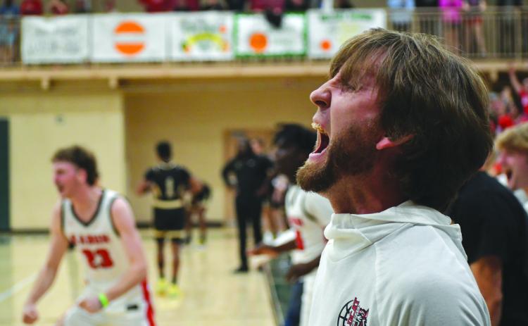 Wesley Branch/The Clayton Tribune. Rabun County Wildcat head coach David Adcock yells in celebration as the buzzer sounds in Rabun County's 58-53 overtime win over Commerce on Feb. 20 at Piedmont University to claim the region tournament championship. The win gave Rabun County back-to-back region titles for the first time in program history. RCHS also defeated Chattooga in the first round of the state tourney on Tuesday.